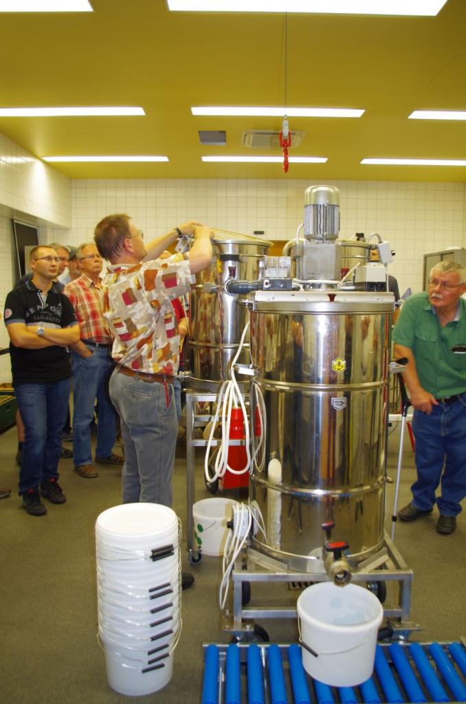 Eingehängte Grob- und Feinsiebe klären den auf etwa halber Höhe wieder austretenden Honig. Das Rührgefäß am Ende mischt eine einheltliche Charge aus 300 kg Honig, die am Ende 22 Eimer und damit eine Euro-Palette füllen.